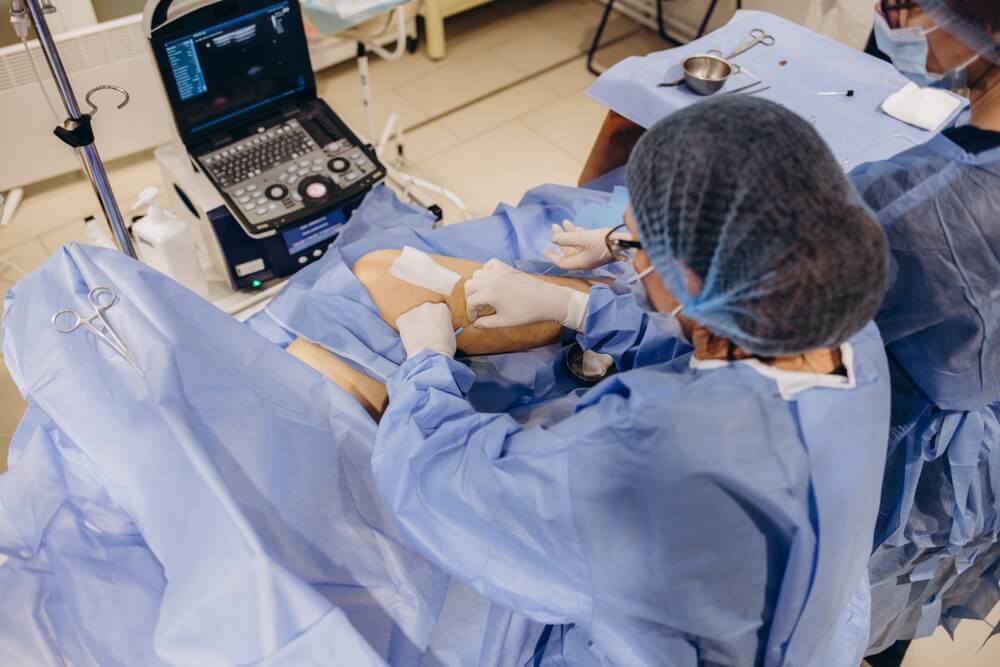 Nelson Vein Clinic specialists in Cleveland, Ohio performing varicose vein surgery with ultrasound guidance in an operating room.